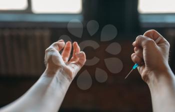 Female junkie hands with syringe, grunge room interior on background. Drug addiction concept, addicted people