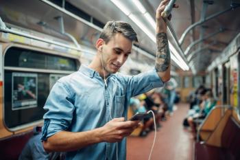 Young man using phone in metro, addiction problem, social addicted people, modern underground lifestyle