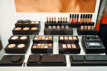 Face cosmetic set in beauty shop closeup, nobody. Makeup products on showcase in store, powders and brushes