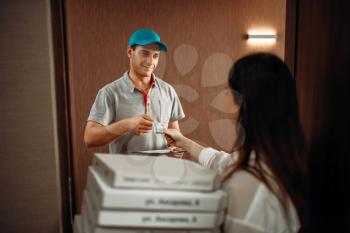 Female customer gives a tip to the courier for fast delivery of hot pizza, quick delivering service. Deliver from pizzeria and woman with carton boxes at the door