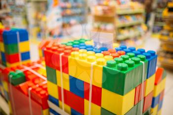 Colorful cubes in toy store, educational games for preschooler. Big plastic bricks in shop for children closeup view, nobody