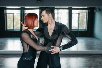 Man and woman on ballrom dance training in class. Female and male partners on professional pair dancing in studio
