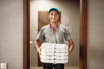 Delivery man with fresh pizza in carton boxes, delivering service. Courier from pizzeria holds cardboard packages