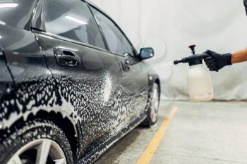 Carwash service, cleaning the wheels with a special agent. Auto detailing, washing with spray