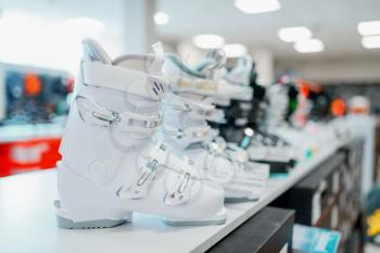 Row of ski and snowboarding boots in sports shop, closeup, nobody. Winter extreme, active leisure, showcase with protect equipment
