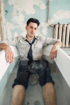 Sad businessman bankrupt in bathtub, suicide man concept. Problem in business, stress