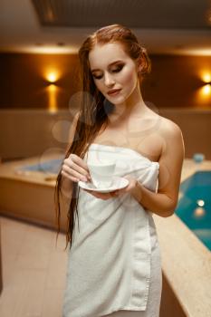 Young woman in towel on the body at the pool indoors. Swimming and relaxation, healthy lifestyle, spa therapy