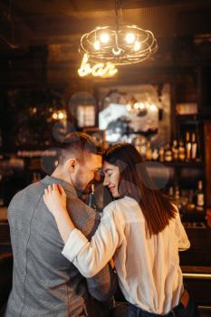 Man and woman relax, couple hugs in bar. Lovers leisures in pub, husband and wife relaxing together in nightclub