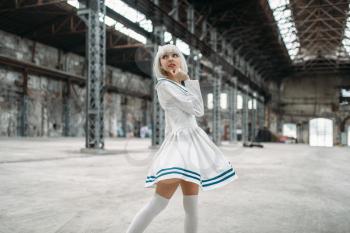 Anime style girl, blonde woman with makeup. Cosplay, japanese culture, doll in dress on abandoned factory