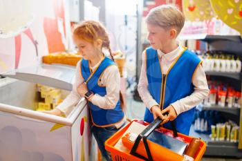 Children in uniform, boy and girl playing salesmen, playroom. Kids plays sellers in imaginary supermarket, salesman occupation learning