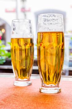 Two glasses of fresh beer on the table in pub. Drinks counter in nightclub or restaurant