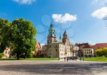Group of tourists walking in Wawel castle, Krakow, Poland. European town with ancient architecture buildings, famous place for travel and tourism