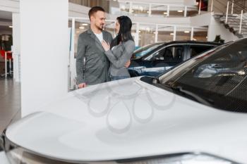 Couple choosing new car in showroom. Male and female customers looks vehicle in dealership, automobile sale, auto purchase