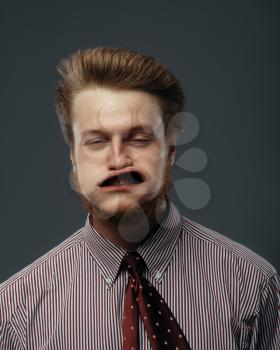 Strong wind blowing in male face, funny emotion. Powerful air flow blows on businessman on black background