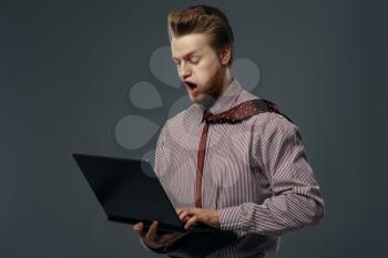 Strong wind blowing on man with laptop, funny emotion. Powerful air flow blows on businessman on black background