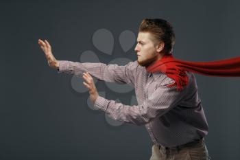 Strong wind blowing on man in red scarf, funny emotion. Powerful air flow blows on businessman face, black background