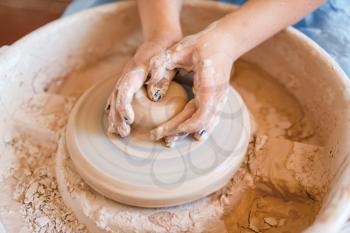 Female potter shaping a pot on pottery wheel. Woman molding a bowl. Handmade ceramic art, tableware from clay