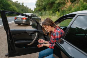 Female driver with broken eyebrow after car accident on road. Automobile crash, blood on the woman's face. Broken automobile or damaged vehicle, auto collision on highway