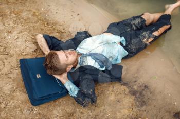 Office worker in torn suit resting on the beach on desert island. Business risk, collapse or bankruptcy concept