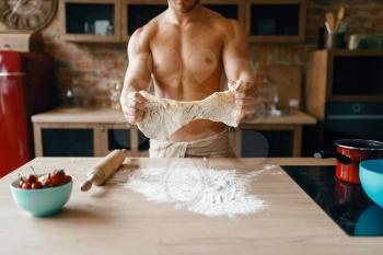 Athletic husband in underwear cooking on the kitchen. Naked man preparing breakfast at home, food preparation without clothes