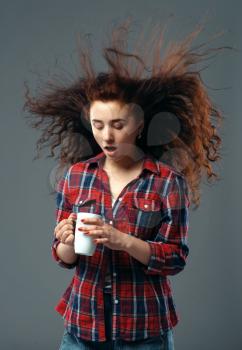 Strong wind blowing on woman's hair, funny grimace. Powerful air flow blows on female person, black background