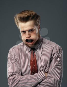 Strong fan blowing on man, funny emotion. Powerful air flow blows on businessman face, black background