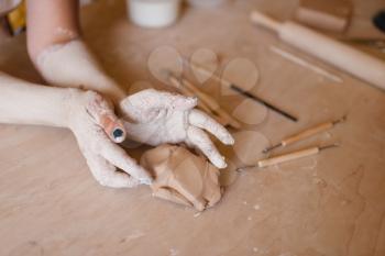 Female potter hands covered with dried clay, pottery workshop. Woman molding a bowl. Handmade ceramic art, tableware making