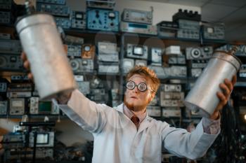 Strange scientist holds radiation devices in his hands, dangerous test in laboratory. Electrical testing tools on background. Lab equipment, engineering workshop