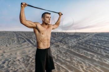 Male athlete in sportswear, fit cross workout in desert at sunny day. Strong motivation in sport, strength outdoor training