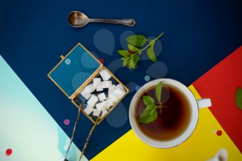 Table setting, tea with mint, teacup and sugar cubes in box, nobody. Luxury silverware on tablecloth, tableware outdoors