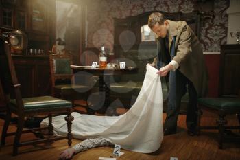 Male detective in coat looking on victim's body at the crime scene, retro style. Criminal investigation, inspector is working on a murder, vintage room interior on background