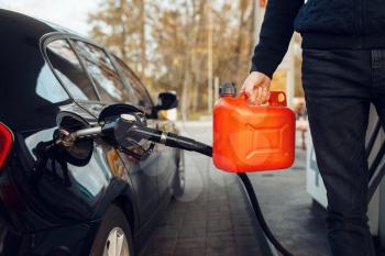 Man holding a canister on gas station, fuel filling. Petrol fueling, gasoline or diesel refuel service, petroleum refueling
