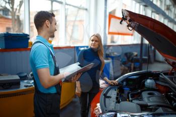 Woman and worker with checklist, car service. Female client on auto station. Automobile checking and inspection, professional diagnostics and repair