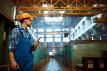 Master looks at the work of the crane operator on metal factory. Metalworking industry, industrial manufacturing of steel production