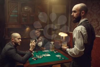 Three poker players sitting at the table in casino. Games of chance addiction, gambling house,