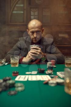 Poker player in suit plays in casino, risk addiction. Games of chance. Man leisures in gambling house, gaming table with green cloth