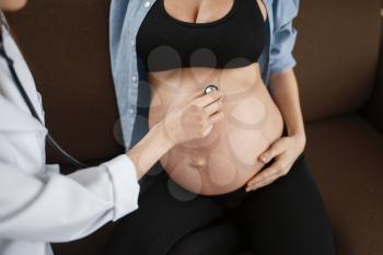 Pregnant woman with belly and a therapist at home. Pregnancy, health care of mother and unborn baby in prenatal period. Expectant mom, healthy lifestyle