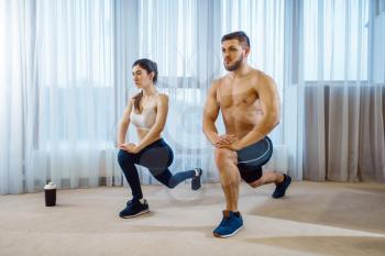 Morning fit workout of love couple at home. Active man and woman in sportswear doing push up exercise in their house, healthy lifestyle, physical culture