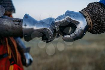 Medieval knights hands in metal gloves closeup view, great tournament. Armored ancient warrior in armour posing in the field