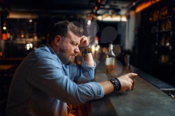 Sad bearded man sitting at the counter in bar. One angry male person in pub, human emotions and leisure activities, depression, stress relief