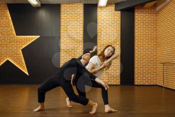 Two female contemporary dance performers poses in studio. Dancers training in class, modern elegance dancing