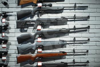 Rifles on showcase in gun shop closeup, nobody. Euqipment for hunters on stand in weapon store, hunting and sport shooting hobby
