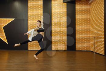 Contemporary dance performer, woman in studio, body flexibility. Dancer on workout in class, modern ballet dance