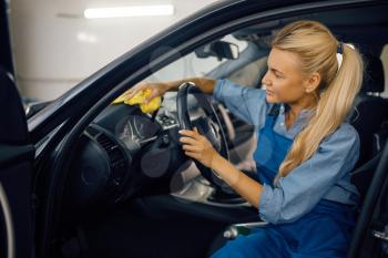 Female washer with sponge cleans automobile interior, car wash service. Woman washes vehicle, carwash station, car-wash business