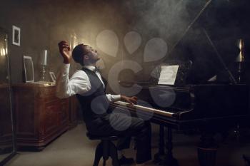 Black grand piano player, jazz performance in club. Negro performer poses at musical instrument before playing melody
