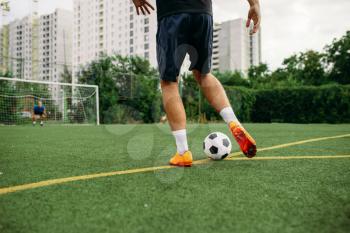 Male soccer player working with ball on the field. Footballer on outdoor stadium, workout before game, football training
