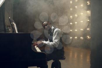 Black grand piano player, jazz performance in club. Black performer poses at musical instrument before playing melody