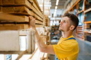 Male builder choosing repair materials in hardware store. Customer look at the goods in diy shop