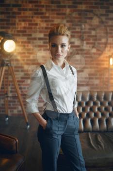 Elegance business woman in strict clothes poses in studio, retro fashion, gangster style, mafia. Vintage lady in office with brick walls