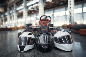 Go kart car and helmets on the ground, karting auto sport indoor. Speed racing go-kart track. Fast vehicle competition, hot pursuit